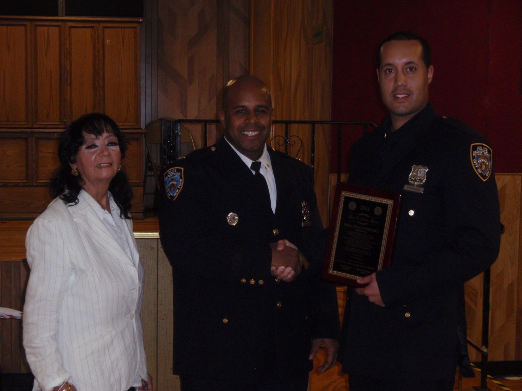 THE COURIER/Photo by Erica Camhi. Deputy Inspector Armando DeLeon (center) and Community Council President Maria Thomson (left) presented Heriberto Rodriguez with the Cop of the Month award.
