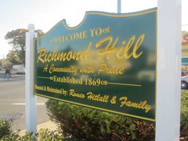 THE COURIER/Photo by Ricky Casiano  The “Welcome to Richmond Hill” sign stands on a triangle at an intersection between Liberty Avenue and 133rd Street.