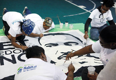 Volunteers paint Roy Wilkins center during MLK event