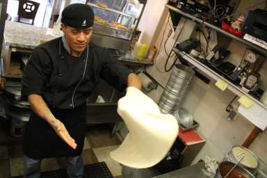 Francisco Duran prepares the first pizza pie of the day.
