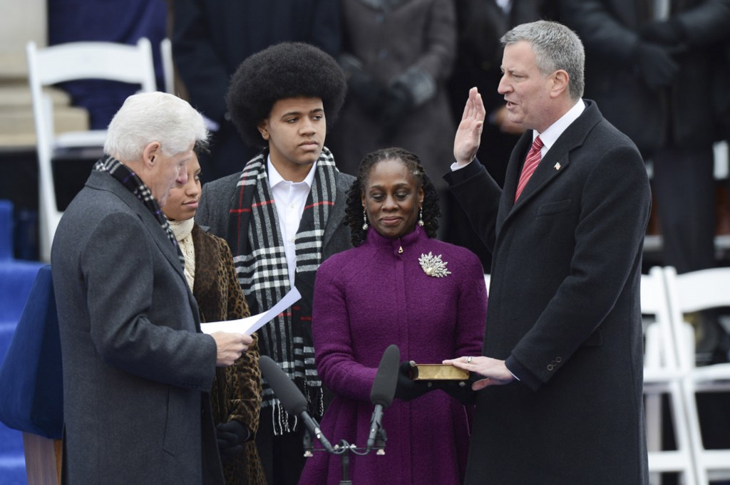 New York City Mayor Bill de Blasio takes the oath of office from former U.S. President Bill Clinton during his inaugural ceremony at City Hall in New York