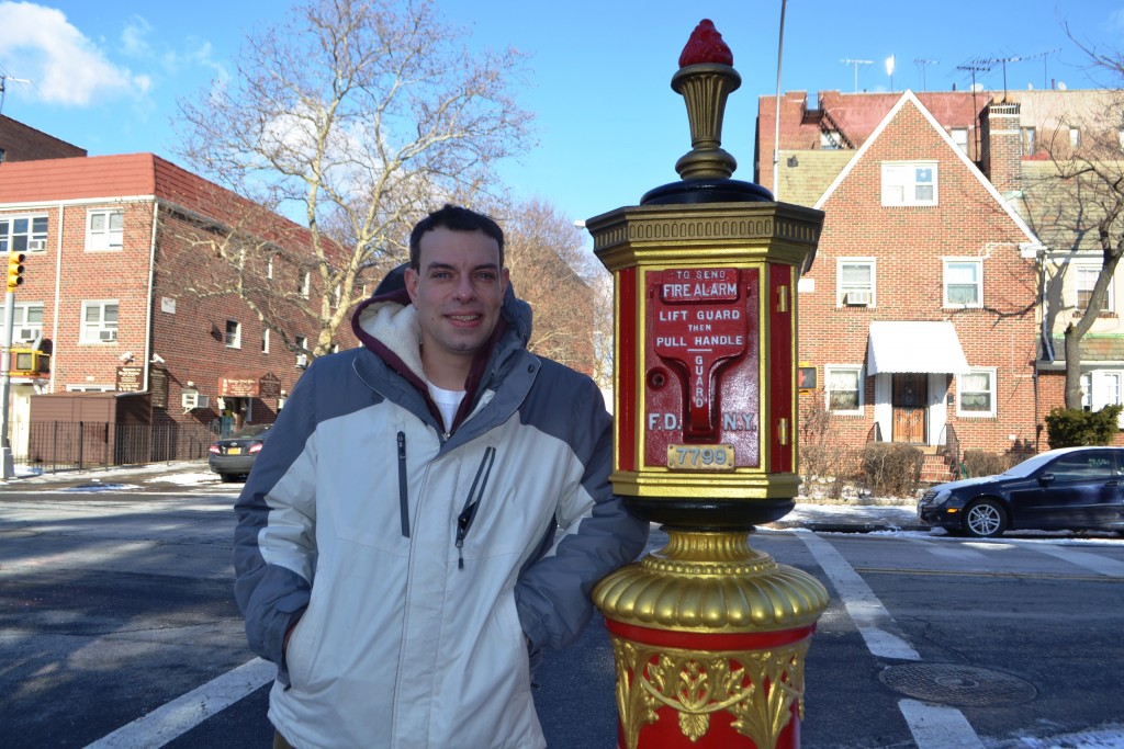 John S. Colgan next to one of the fire alarm boxes he painted on 54th Street and 32nd Avenue in Woodside.