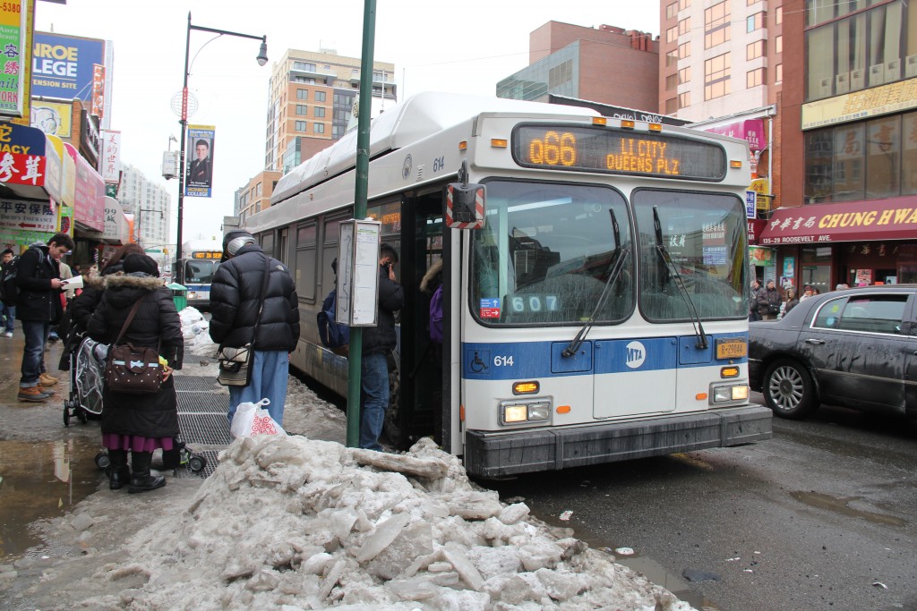 Flushing serves as a major transportation hub, with throngs of people transferring between buses and trains.