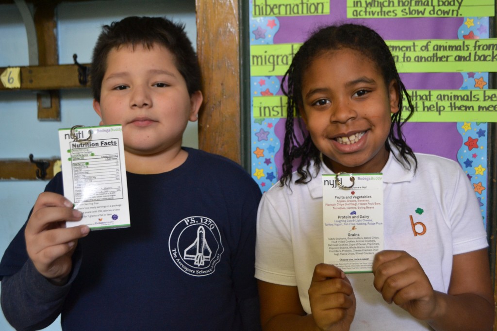 Third graders Kevin Lopez and Tyla Hooks each hold a "Bodega Buddy."