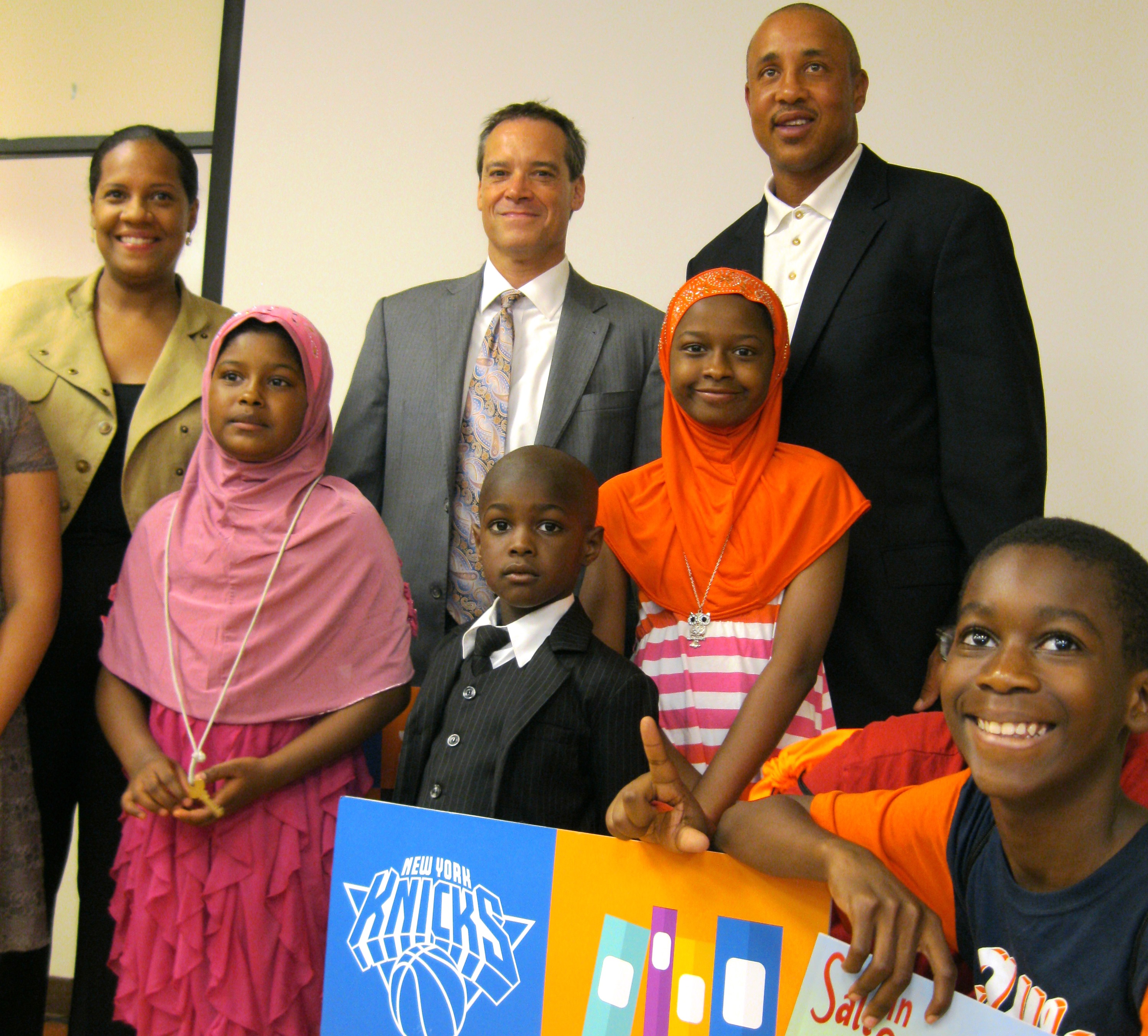 Legendary Knicks shooting guard John Starks (top right) visited the Queens Library at LeFrak City on Aug. 11 as part of the 9th annual “Knicks Read to Achieve” summer reading program.