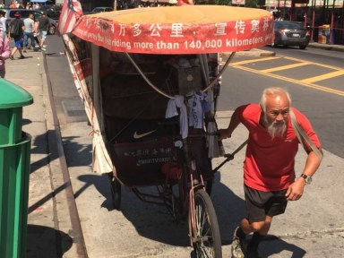 Chen Guanming pulling his rickshaw in the streets of Flushing.