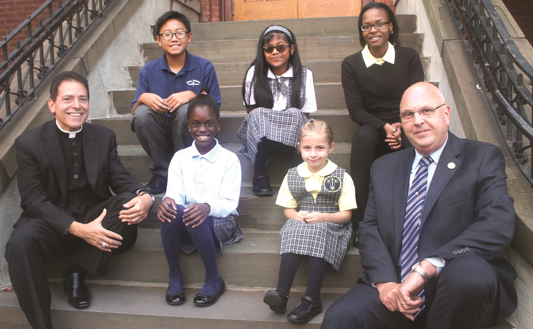 Monsignor Jamie Gigantiello and Superintendent of Schools for the Diocese of Brooklyn Thomas Chadzutko with youngsters Omodele Ojo, Brianna Wood, Maria Teresa Heyer, Raymond Ricco and Christina Desanges.