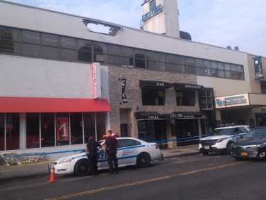 On Monday morning, police sealed off the sidewalk under the scene where a car crashed into a wall on a rooftop parking lot in Forest Hills.