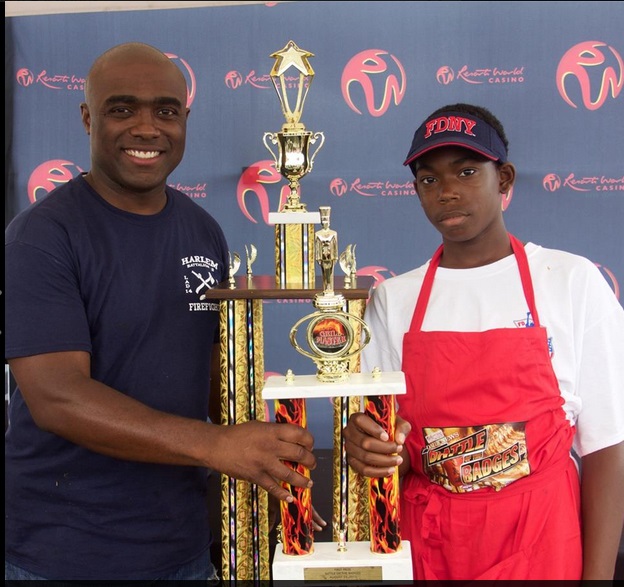 FDNY firefighter Khalid Baylor of Ladder 14 in East Harlem, pictured with his son, won the first annual Battle of the Badges Cook-Off at Resorts World Casino.