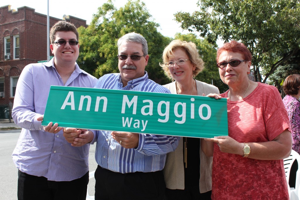 Ann Maggio’s grandson Andrew, son Anthony, daughter-in-law Tracy and daughter Joann holding up the new street sign as a tribute to their mother.