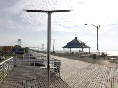Charging stations in public parks, similar to this one, are part of the ways AT&T is expanding its services and outreach in Queens.