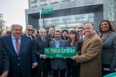 Officials and Patrolman Cardillo’s son, Todd Cardillo, pose with the new street sign.