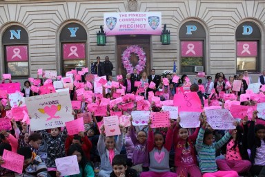 Students and faculty from P.S. 88 in Ridgewood held up their handmade signs on the steps of the 104th Precinct during the first annual Pink Parade for Breast Cancer Awareness.