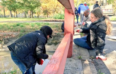 Former first daughter Chelsea Clinton (at right) helps repaint a fence at Brookville Park Saturday morning as part of The Clinton Foundation's "Day of Action."