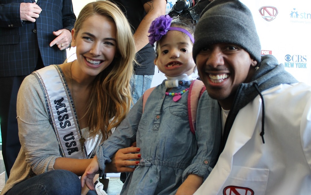 Nick Cannon poses with a St. Mary's patient and Miss USA Olivia Jordan.