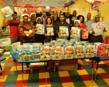 Event participants with some of the toys given away at the Saratoga Family Inn.