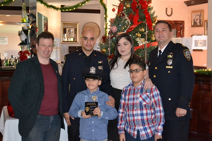 P.O. Gonzalez (center) and his wife and two sons accepting the Cop of the Year award from 104th Precinct Community Council president, Len Santoro (left) and Capt. Mark Wachter (right).