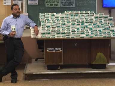 Deputy Inspector Jeffrey Schiff, 106th Precinct commander, shown next to a pile of untaxed cigarette cartons that the precinct seized last week.