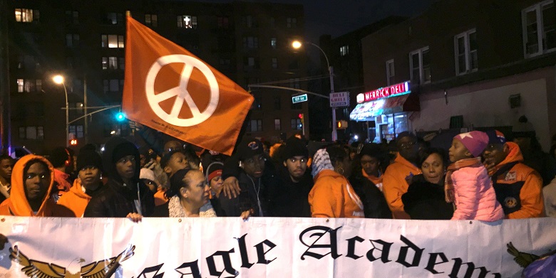 Carrying flags and wearing shirts bearing the peace symbol, residents in Jamaica marched on Thursday night calling for action to stop gun violence throughout the community and country.