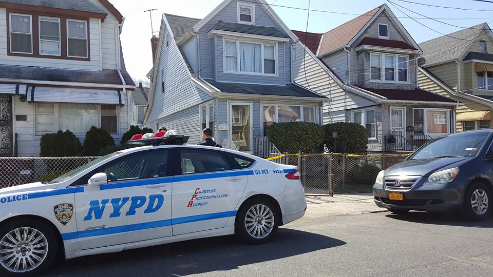 Officers from the 113th Precinct stand guard outside a South Jamaica home that armed robbers invaded on Thursday.