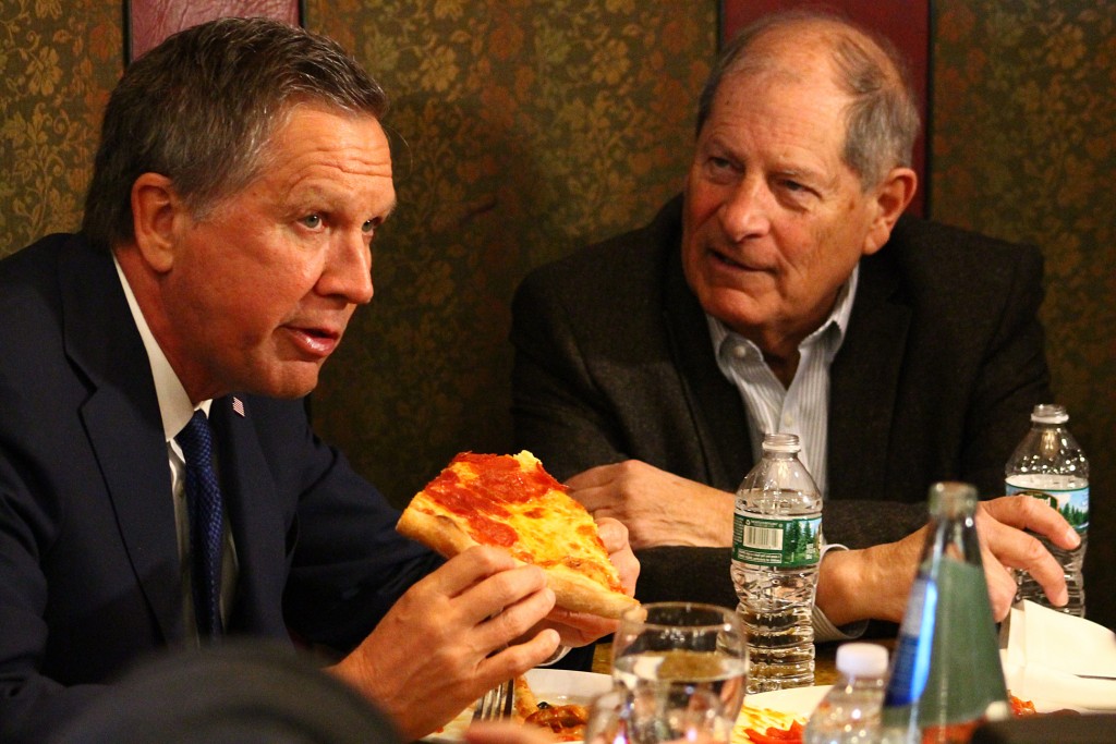 Ohio Governor John Kasich enjoys pizza in Howard Beach Tuesday with Queens County GOP Chairman Robert Turner.