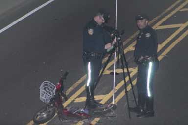 Members of the NYPD Highway Patrol Collision Investigation Squad near the scooter involved in a crash in Glendale Saturday morning.