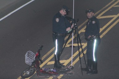 Members of the NYPD Highway Patrol Collision Investigation Squad near the scooter involved in a crash in Glendale Saturday morning.