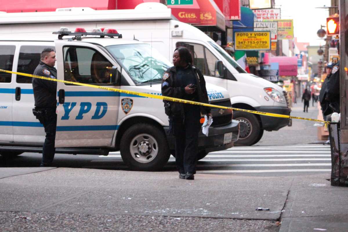 Officers at the corner of Roosevelt Avenue and 81st Street in Jackson Heights, where a man was beaten to death on Sunday morning.