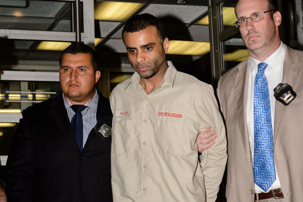 Oscar Morel (center) is led out of the 107th Precinct stationhouse Monday night after being charged with killing an Ozone Park imam and his assistant on Aug. 13.
