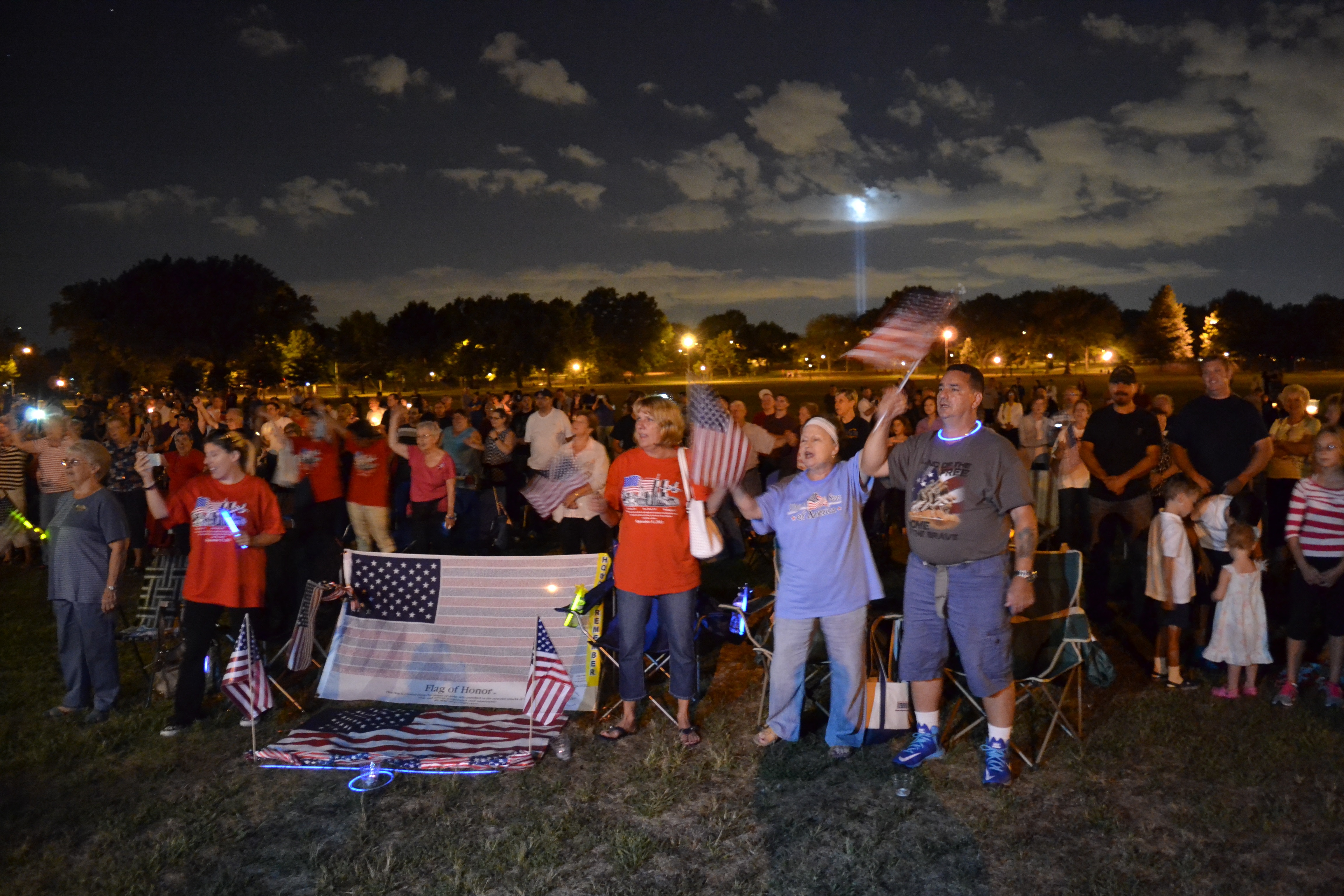 The 9/11 memorial service in 2015 at Juniper Valley Park in Middle Village, with the Tribute in Light in the background.