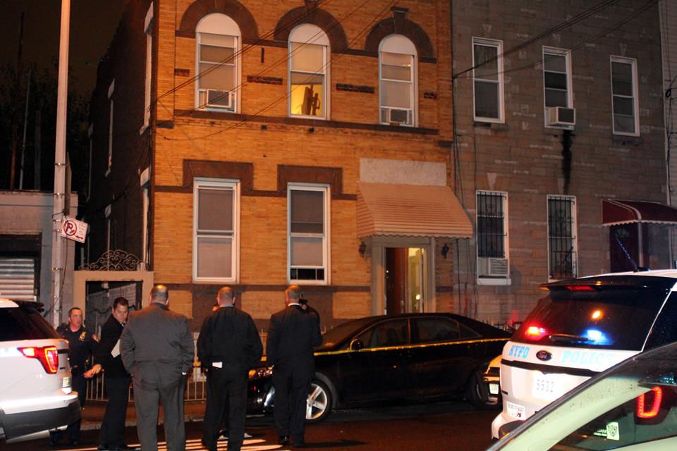 Detectives approach the apartment house on Stanhope Street where a 26-year-old woman was murdered Wednesday night.