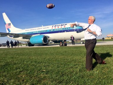 Republican vice presidential nominee Mike Pence throws a football in front of his campaign's charter jet in Iowa, five hours before it skidded off a runway at La Guardia Airport on Thursday night.