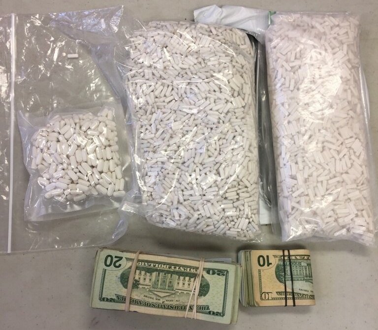 Bags of prescription pills and wads of cash seized from a Flushing driver o...