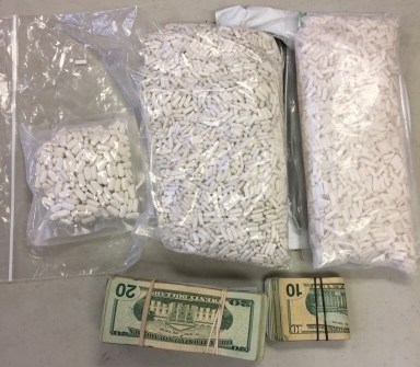 Bags of prescription pills and wads of cash seized from a Flushing driver on Jan. 12.