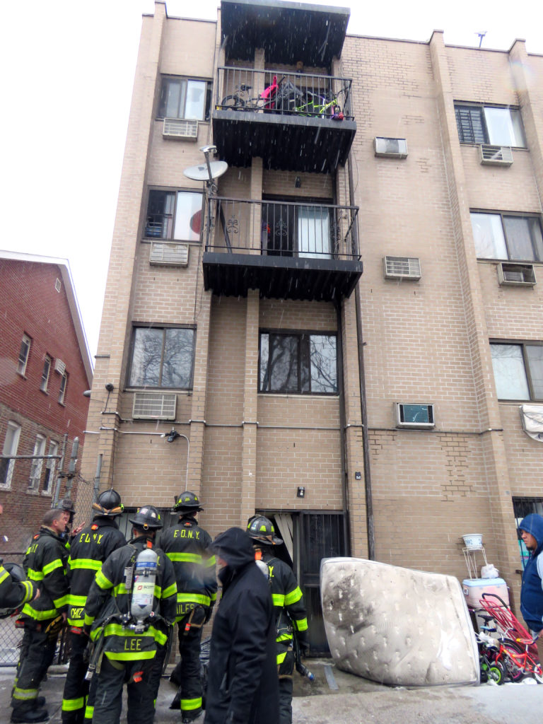 firefighter look over building where children jumped from the second floor at 56-14 Waldron st. in corona Queens , the kids alond with the pets had to jump from the second floor and were caught by the building super Roberto Flores. Photos by Robert Stridiron. 02/12/17