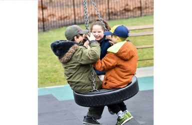 Kids play on the new tire swing at Joseph DeVoy Playground in Forest Hills.
