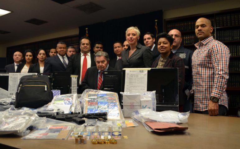 Queens District Attorney Richard A. Brown with detectives and prosecutors showing some of the items seized as part of the crackdown of a massive credit card fraud ring in Queens.