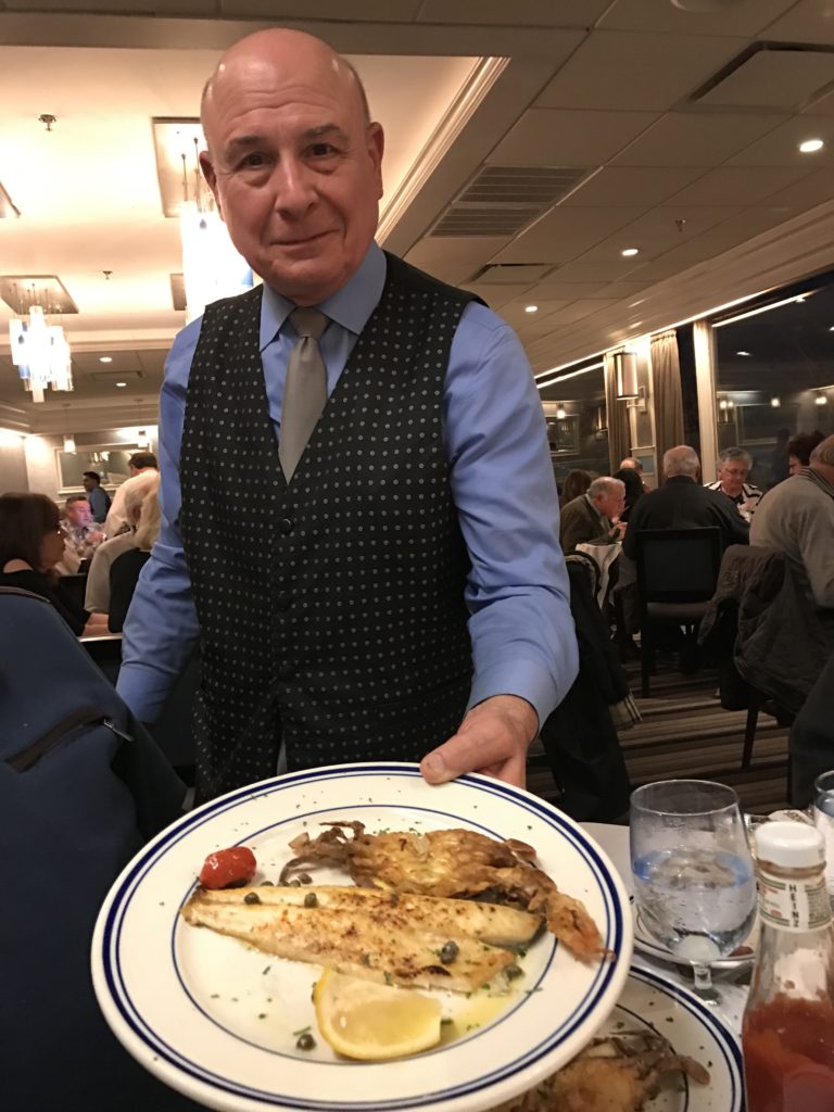 Long term waiter Bobby, serving branzino and Maryland crab cakes.