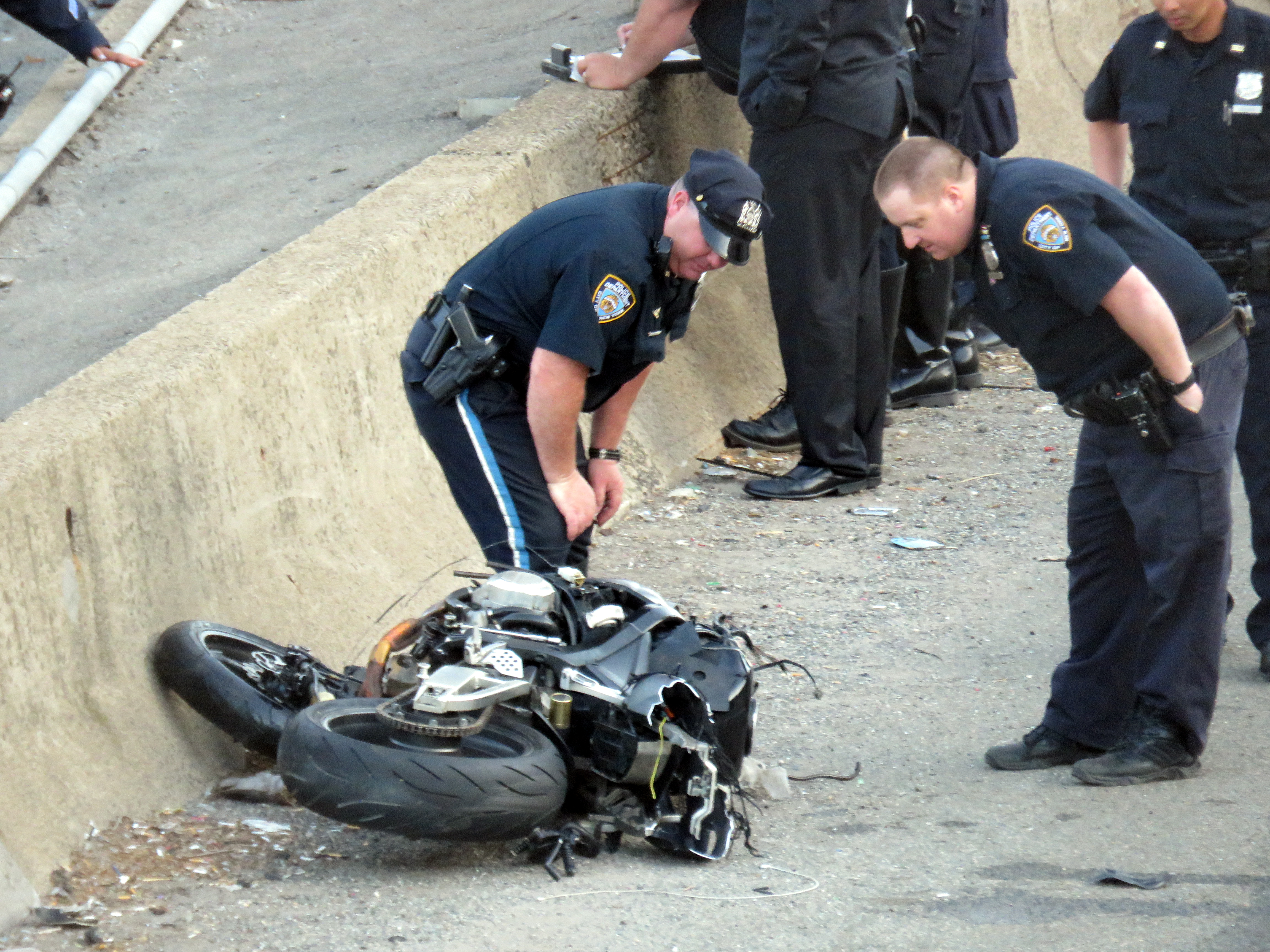 Cops inspect a motorcycle following a deadly crash on the Van Wyck Expressway on May 21.