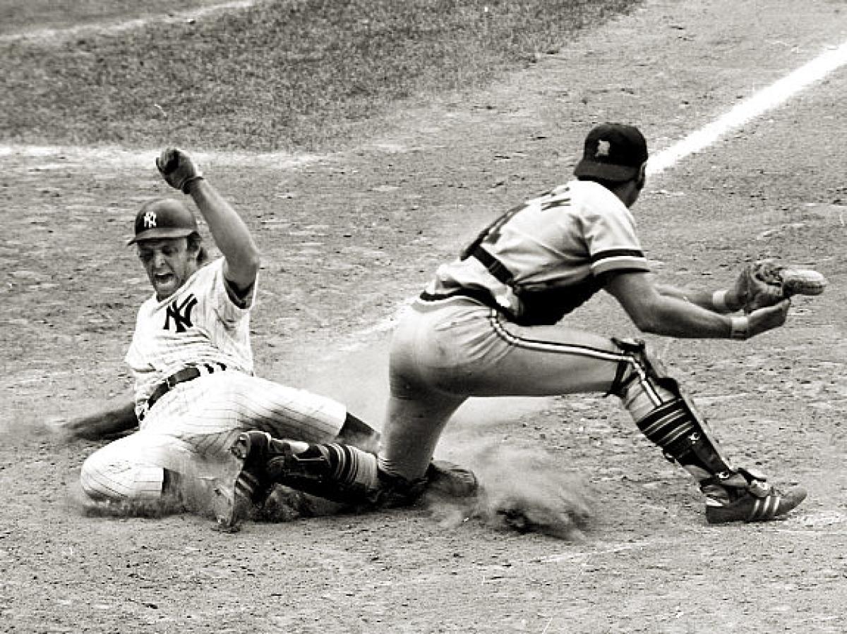 New York Yankee Ron Blomberg, MLB's first-ever designated hitter, slides into home plate during a game against the Detroit Tigers.
