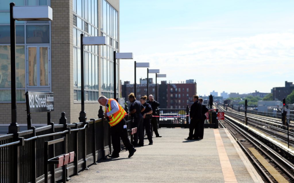 Cops examine the spot on the 82nd Street station where the man fell to his death.