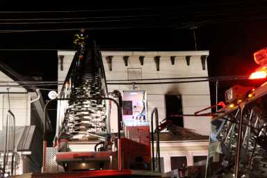A ladder extends up to the second floor of a home on 114th Street in Richmond Hill after a fire broke out there on Sept. 26.