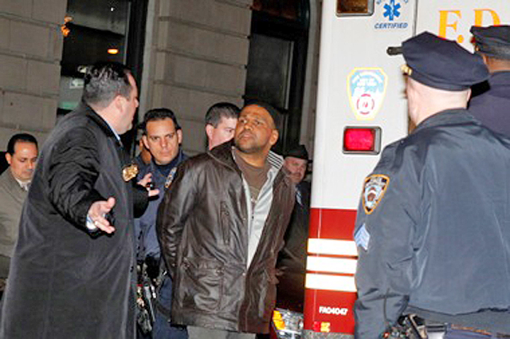 Ray Lazier Lengend is escorted out of the 103rd Precinct stationhouse in Jamaica in January 2012 after being charged with multiple firebombings.