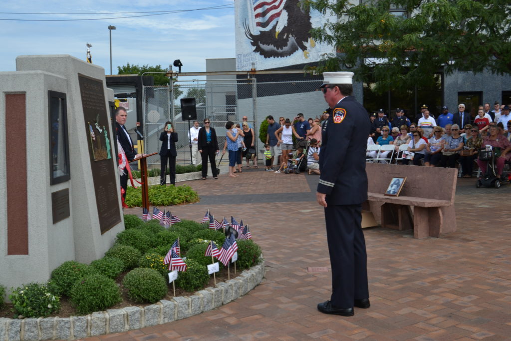 A firefighter salutes at the Maspeth 9/11 memorial. (photo: Anthony Giudice/QNS)