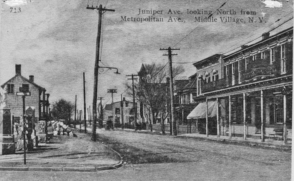 Look carefully at the signpost at far left and you’ll see the sign for Metropolitan Avenue. But as this photo notes, the intersection is at Juniper Avenue, which is now 69th Street.