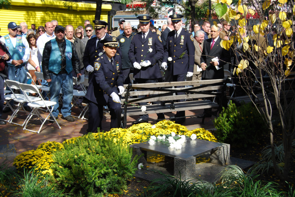 NYPD Assistant Chief Diana Pizzuti leaves a flower on the memorial plaque at Venditti Square in 2011. (Photo: Robert Pozarycki/RIDGEWOOD TIMES)