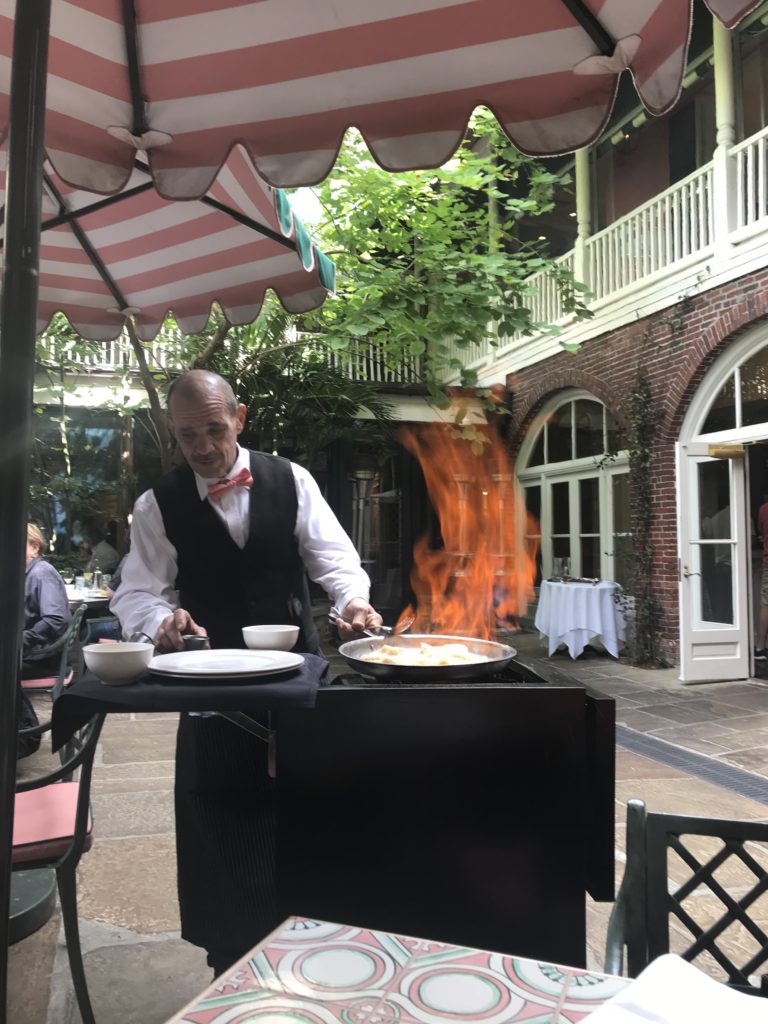 The waiter prepares flambee crepes on the patio at Brennan's Restaurant