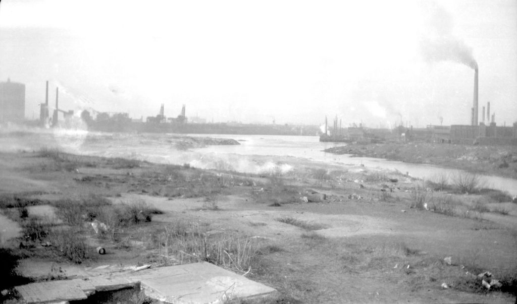 A site in Maspeth looking west toward the Newtown Creek in 1934. Look carefully at the left of the photo and you’ll see the outline of one of the former Greenpoint gas tanks; both tanks were demolished in 2001. (Courtesy of the Queens Borough Public Library, Archives, Ralph S. Solecki Photographs)