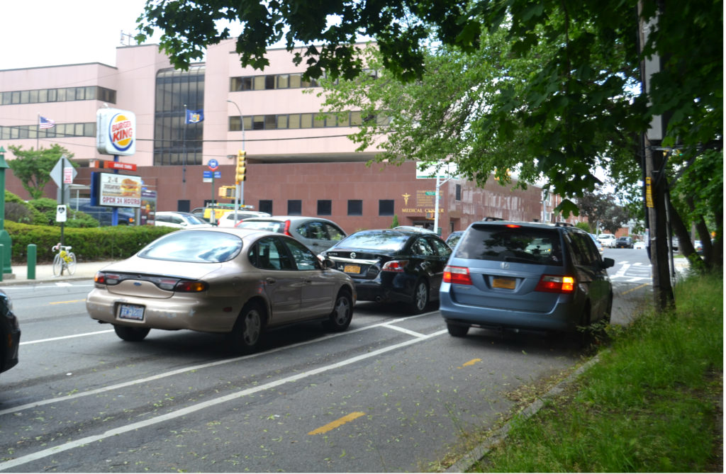 A minivan drives through the bike lane while approaching Northern Boulevard