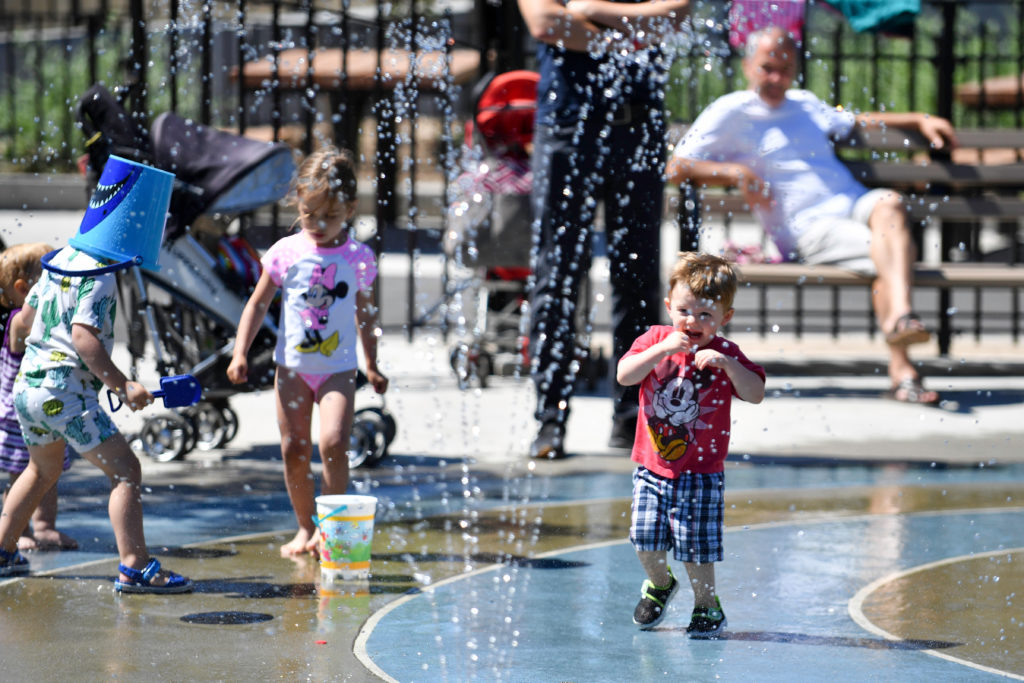 A young boy plays in the new sprinklers at Astoria Heights Playground